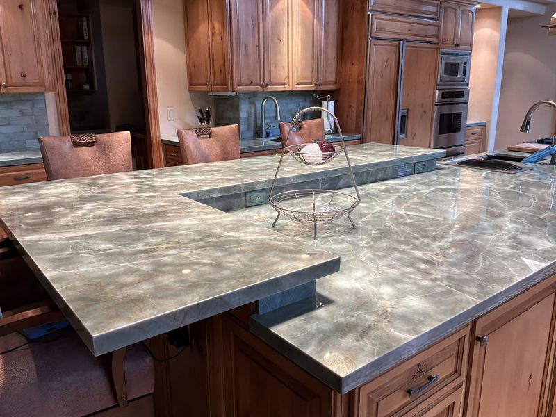 Close-up of a polished quartzite island with a raised bar